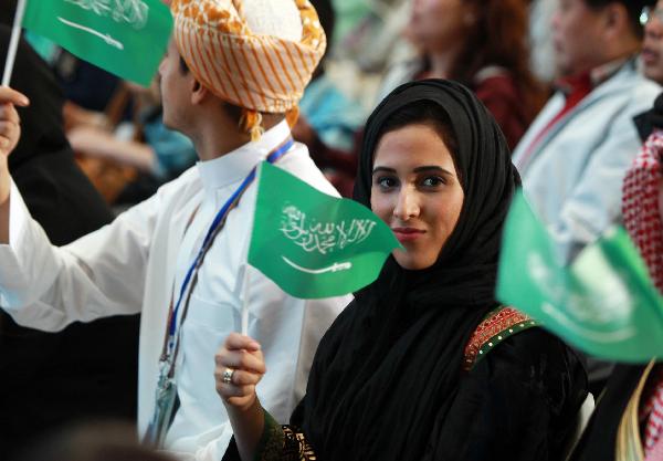 A woman waves the national flag of Saudi Arabia at a ceremony marking the National Pavilion Day for Saudi Arabia at the 2010 World Expo in Shanghai, east China, Sept. 23, 2010.