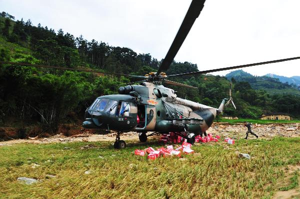 A military helicopter is seen on a drop-off point in Xinyi, south China&apos;s Guangdong Province, Sept. 25, 2010. Since torrential rainstorm brought by Typhoon Fanabi hit Guangdong this week and caused serious waterlog, China&apos;s army aviation regiment has bridged an air lifeline by airdropping daily necessities to disaster-stricken people.