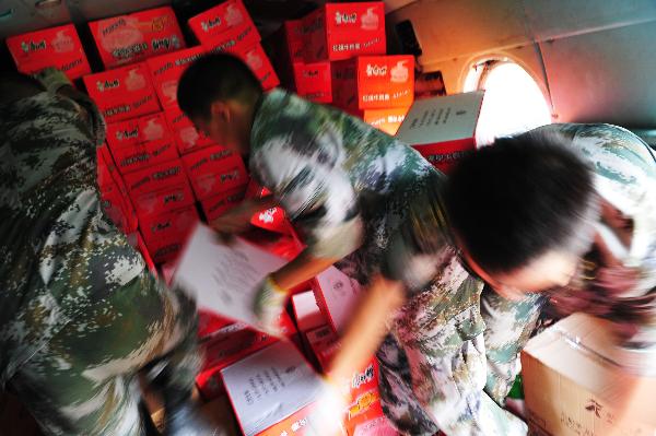 Soldiers transfer materials on a military helicopter in Pingtang village of Xinyi, south China&apos;s Guangdong Province, Sept. 25, 2010. Since torrential rainstorm brought by Typhoon Fanabi hit Guangdong this week and caused serious waterlog, China&apos;s army aviation regiment has bridged an air lifeline by airdropping daily necessities to disaster-stricken people.