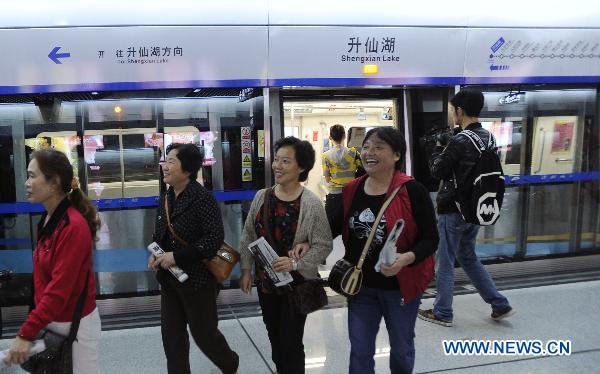 Passengers walk out of a carriage on the newly opened subway line in Chengdu, capital of southwest China's Sichuan Province, Sept. 27, 2010. After four years' construction, the subway Line 1 in Chengdu witnessed its pilot run Monday.