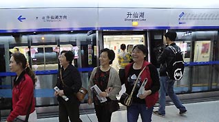 Passengers walk out of a carriage on the newly opened subway line in Chengdu, capital of southwest China's Sichuan Province, Sept. 27, 2010. After four years' construction, the subway Line 1 in Chengdu witnessed its pilot run Monday.