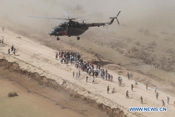 Members of the Chinese helicopter rescue team release relief materials to Pakistani flood victims at a temporary settlement in Pakistan, Sept. 27, 2010. 