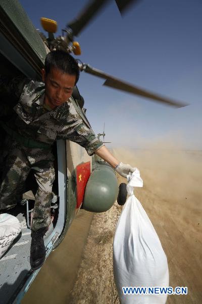 Members of the Chinese helicopter rescue team release relief materials to Pakistani flood victims at a temporary settlement in Pakistan, Sept. 27, 2010. 