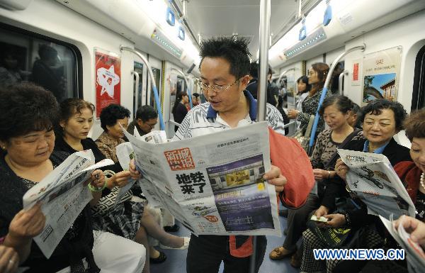 Photo taken on Sept. 27, 2010 shows passengers read newspapers in a carriage on the newly opened subway line in Chengdu, capital of southwest China's Sichuan Province.