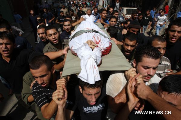 Palestinian mourners carry the body of Islamic Jihad militant Awni Abdelhadi, who was killed by Israeli shelling, during his funeral in the al-Bureij refugee camp, central Gaza Strip, Sept. 28, 2010. Three Palestinian militants from Islamic Jihad movement were killed on Monday night after they were targeted by an Israeli air-to-ground missile in central Gaza Strip, medics and witnesses said. (Xinhua/Wissam Nassar) 