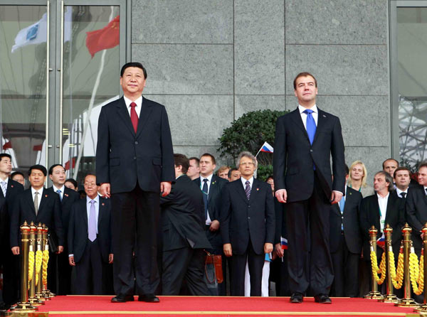 Chinese Vice President Xi Jinping (L) and Russian President Dmitry Medvedev (R) attend a flag-raising ceremony to mark Russia&apos;s National Pavilion Day at Expo Park in Shanghai, Sept 28, 2010. [Xinhua]