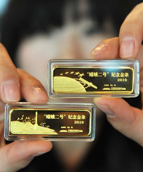 A staff member shows two commemorative gold bars for Chang'e-2 lunar probe in Beijing, capital of China, Sept. 28, 2010. 
