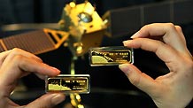 A staff member shows two commemorative gold bars for Chang'e-2 lunar probe in Beijing, capital of China, Sept. 28, 2010.