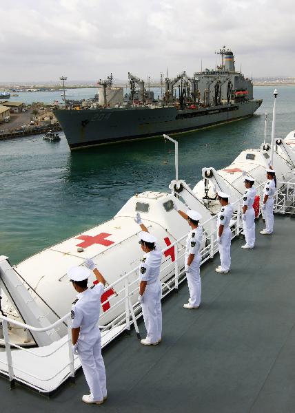 Crew members of China's hospital ship Peace Ark waves goodbye on the deck as the ship leaves the port of Djibouti, Sept. 29, 2010.