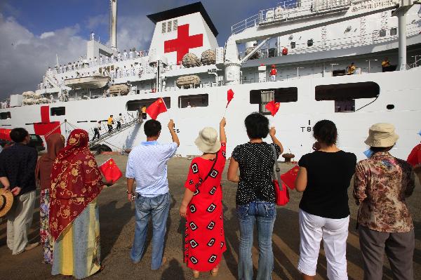 People wave national flags of China and Djibouti in front of China's hospital ship Peace Ark at the port of Djibouti, Sept. 29, 2010.
