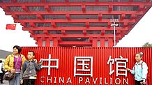 Visitors pose for photos in front of the China Pavilion at the World Expo Park in Shanghai, east China, Oct. 1, 2010. A series of activities are held at World Expo Park to mark China National Pavilion Day on Friday, during the 61st anniversary of the founding of the People's Republic of China.