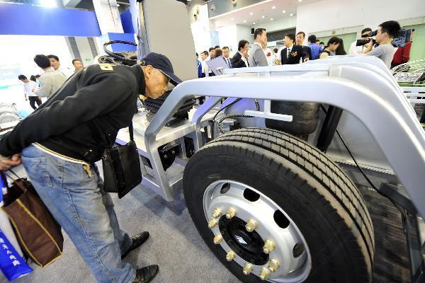 A man inspects the dynamical system of an electric vehicle on a new energy motor show in Hangzhou, east China's Zhejiang Province, Oct. 2, 2010.