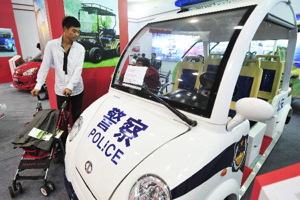 A man looks at a hybird police vehicle on a new energy motor show in Hangzhou, east China's Zhejiang Province, Oct. 2, 2010.