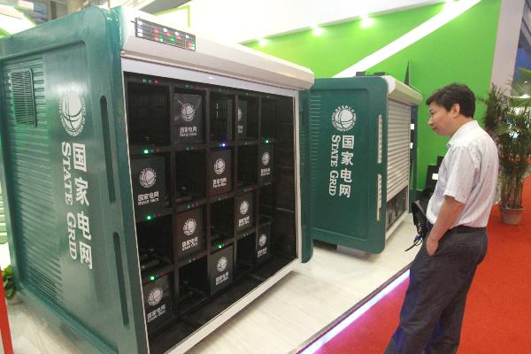 A man looks at a recharging station for electric vehicles on a new energy motor show in Hangzhou, east China's Zhejiang Province, Oct. 2, 2010. 