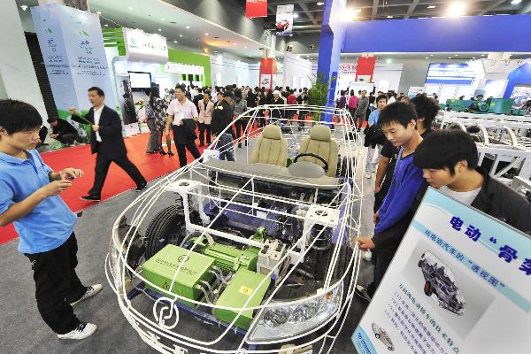 Visitors looks at the dynamical system of an electric vehicle on a new energy motor show in Hangzhou, east China's Zhejiang Province, Oct. 2, 2010. 