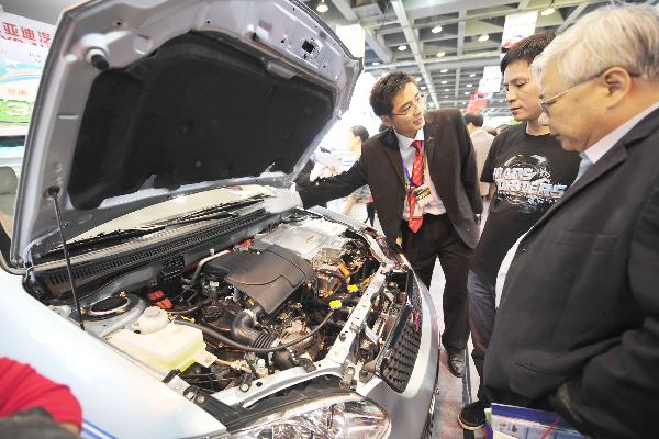 A staff member introduces the dynamical system of an electric vehicle to the visitors on a new energy motor show in Hangzhou, east China's Zhejiang Province, Oct. 2, 2010. 