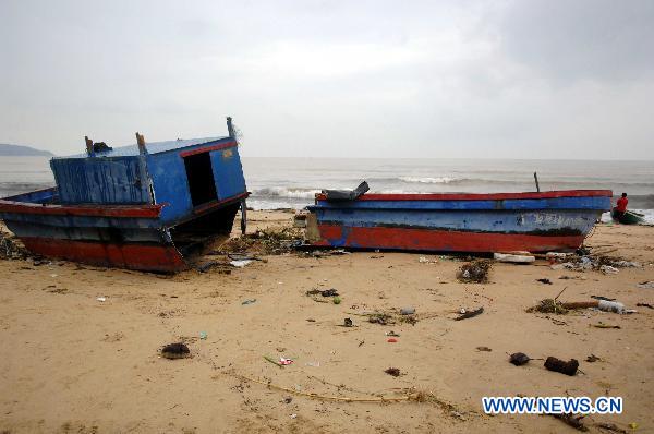 Photo taken on Oct. 6, 2010 shows a fishing boat shattered by heavy rains and waves on a beach in Lingshui County, south China&apos;s Hainan Province.