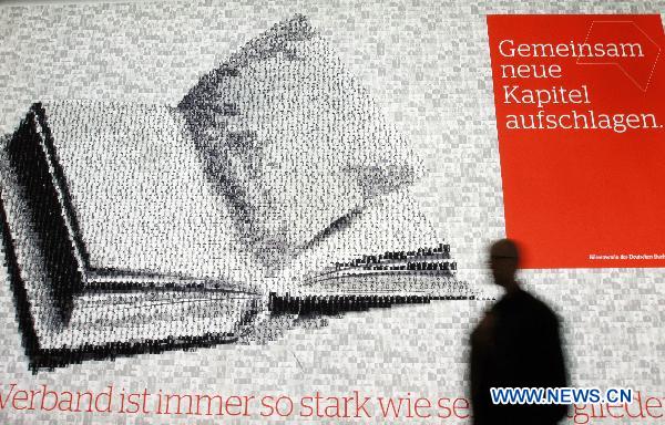 A visitor walks past a poster during the 62nd Frankfurt International Book Fair in Frankfurt, Germany, Oct. 6, 2010.