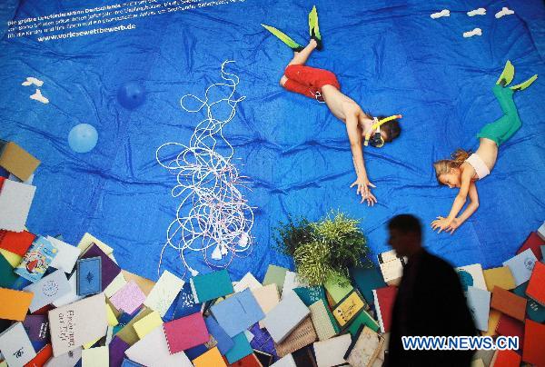 A visitor walks past a poster during the 62nd Frankfurt International Book Fair in Frankfurt, Germany, Oct. 6, 2010.