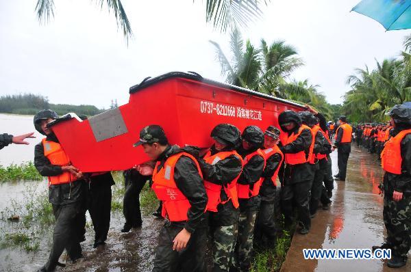 Soldiers carrying a speed boat walk to the Sanjiang reservoir in Haikou, capital of south China&apos;s Hainan Province, Oct. 7, 2010. 