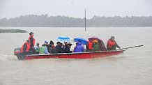 Villagers trapped at the Sanjiang farm are transfered on a speed boat in Haikou, capital of south China's Hainan Province, Oct. 7, 2010.