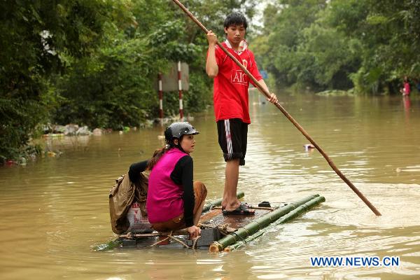Locals sail on a raft in floodwaters in Quang Binh, central Vietnam, on Oct. 7, 2010.