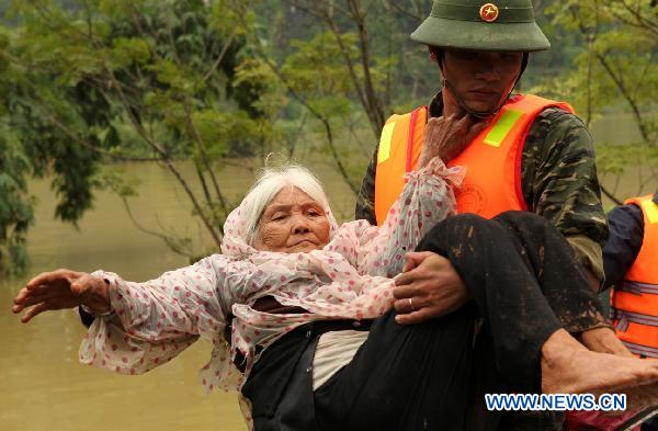 A rescuer holds an elderly woman in Quang Binh, central Vietnam, on Oct. 7, 2010. 