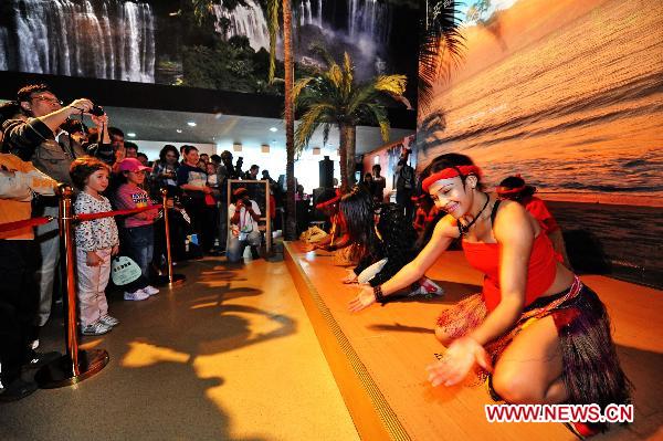 Tourists watch dance performance in the Angola Pavilion in the World Expo Park in Shanghai, east China, Oct. 7, 2010.