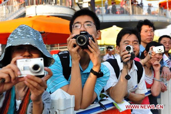 Tourists take photos in the World Expo Park in Shanghai, east China, Oct. 7, 2010.