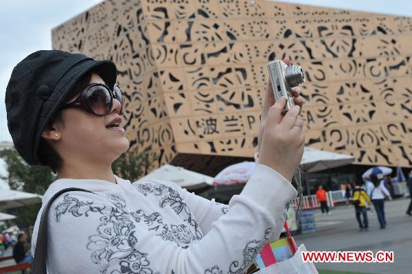 A woman takes photos outside the Poland Pavilion in the World Expo Park in Shanghai, east China, Oct. 7, 2010. 