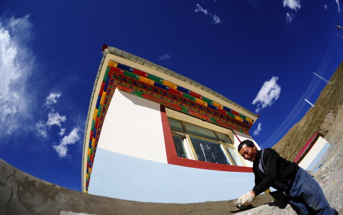 A mason puts the finishing touches to a newly-built house in Yushu County, northwest China's Qinghai Province, on Thursday Oct 7, 2010.