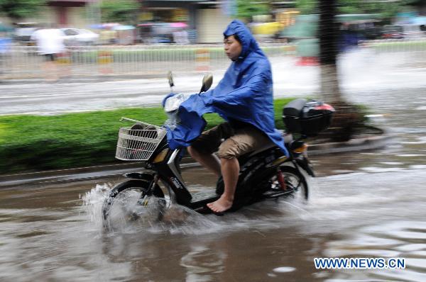 A man rides on a water-flooded road after heavy rainfall in Haikou, capital of south China&apos;s Hainan Province, Oct. 8, 2010. Haikou witnessed successive heavy rainfall for eight days and the rainfall flooded many roads and streets here. Local meteorological department forecasted that the rain won&apos;t stop until Oct. 11. 