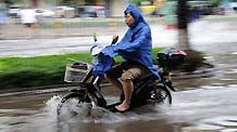 A man rides on a water-flooded road after heavy rainfall in Haikou, capital of south China's Hainan Province, Oct. 8, 2010. Haikou witnessed successive heavy rainfall for eight days and the rainfall flooded many roads and streets here. Local meteorological department forecasted that the rain won't stop until Oct. 11.