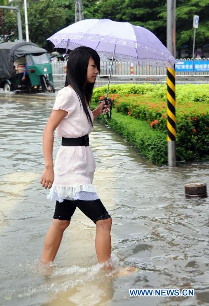 A girl walks in a waterlogged street in Haikou, capital of south China&apos;s Hainan Province, Oct. 8, 2010. 