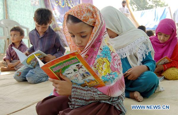 Children affected by floods study at a temporary school in northwest Pakistan&apos;s Nowshera Oct. 8, 2010.