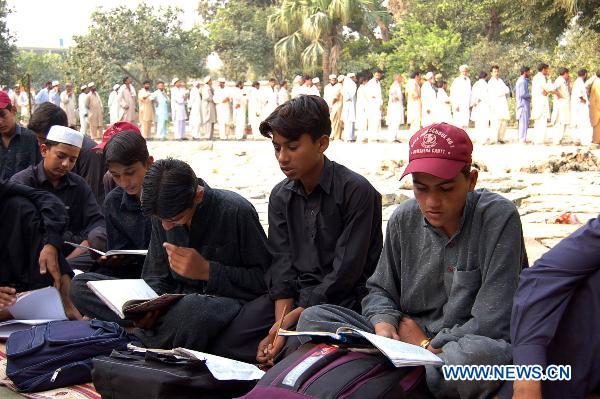 Students affected by floods study at a temporary school in northwest Pakistan&apos;s Nowshera Oct. 8, 2010.