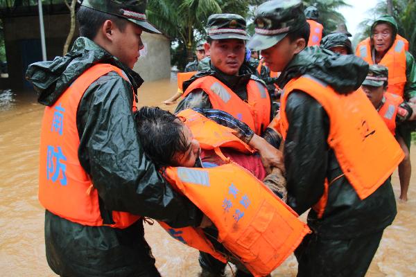 Soldiers evacuate a resident in Huiwen Township of Wenchang City, south China's Hainan Province, Oct. 8, 2010. 