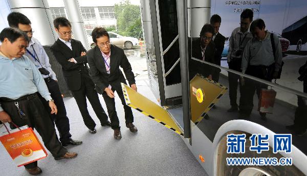Staff members display the wheelchair passenger ramp of a BYD K9 Full Automatic Coach during the 2010 Changsha Science and Technology Achievements Transformation Fair in Changsha, capital of central China's Hunan Province, Oct. 11, 2010.