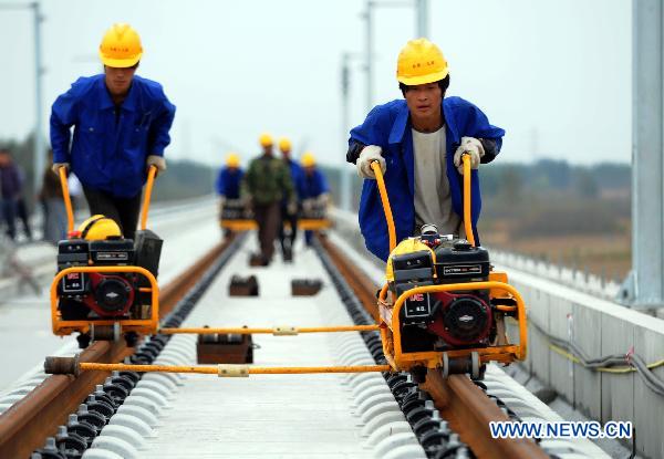 Workers fix up railway track on Beijing-Shanghai High-Speed Railway in Cangzhou City, east China's Hebei Province, Oct. 12, 2010. 
