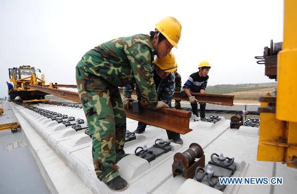 Workers fix up railway track on Beijing-Shanghai High-Speed Railway in Cangzhou City, east China's Hebei Province, Oct. 12, 2010. 