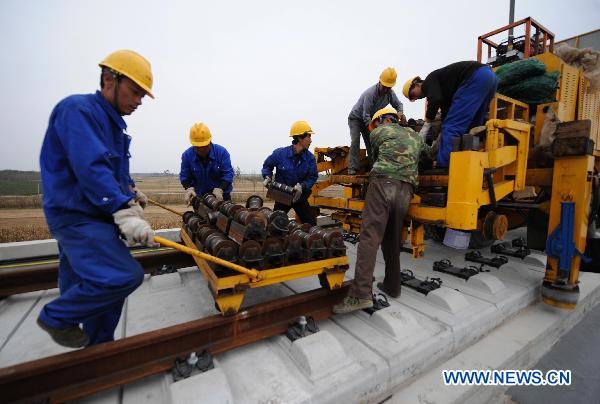 Workers fix up railway track on Beijing-Shanghai High-Speed Railway in Cangzhou City, east China's Hebei Province, Oct. 12, 2010. 