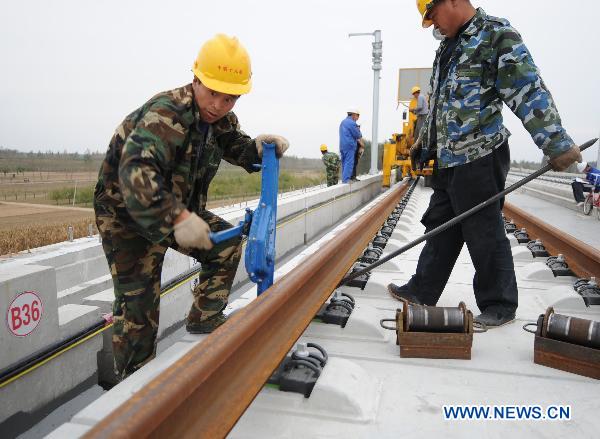 Workers fix up railway track on Beijing-Shanghai High-Speed Railway in Cangzhou City, east China's Hebei Province, Oct. 12, 2010. 