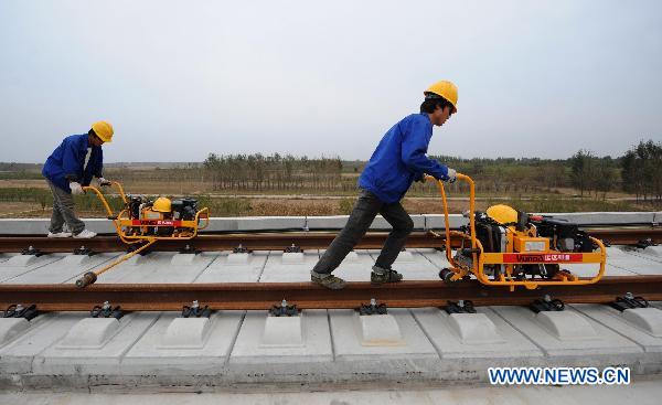 Workers fix up railway track on Beijing-Shanghai High-Speed Railway in Cangzhou City, east China's Hebei Province, Oct. 12, 2010. 