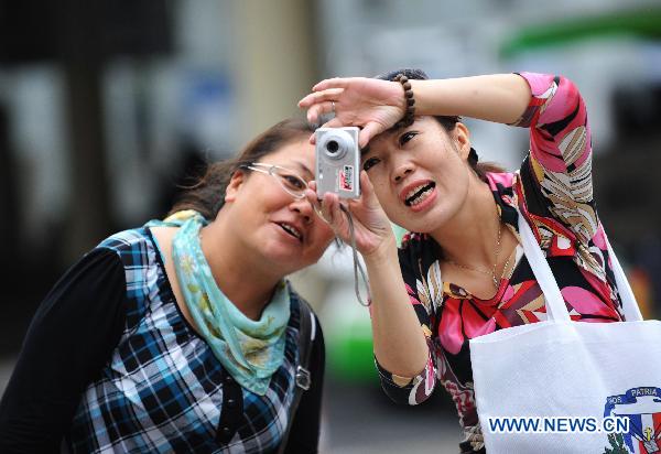Visitors take photos in World Expo Park in east China's Shanghai on Oct. 12, 2010.