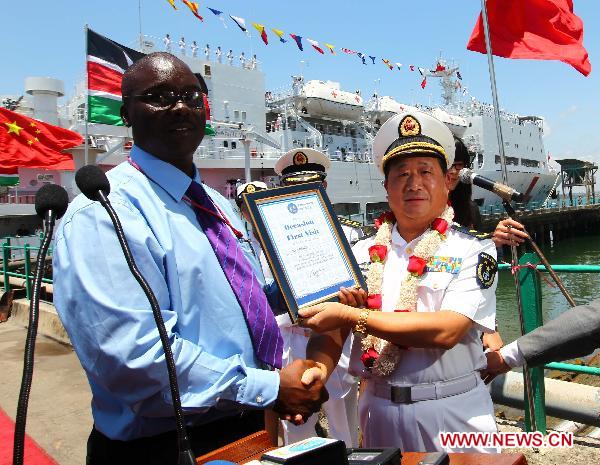 Bao Yuping (R), commander of hospital ship Peace Ark of the Navy of the Chinese People's Liberation Army, is awarded a certificate of Peace Ark's first visit to the port of Mombasa in Mombasa, Kenya, on Oct. 13, 2010. 