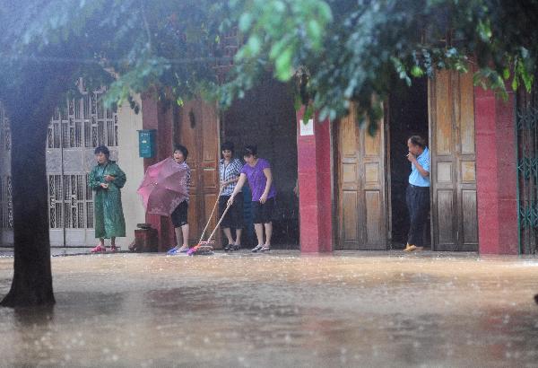 People drain off water from their house in Qionghai, south China's Hainan Province, Oct. 17, 2010. Heavy rainfall hit Qionghai again on Sunday.