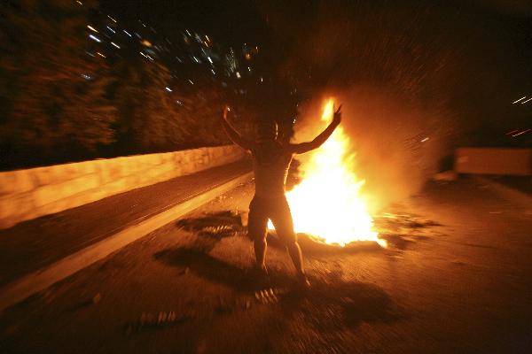A Palestinian youth stands by a fire during the clash with Israeli border police in the East Jerusalem neighbourhood of Silwan Oct. 17, 2010.