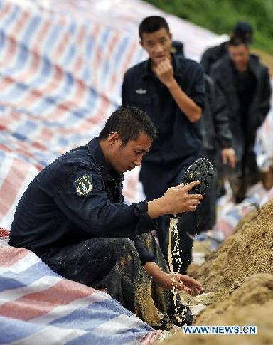 A soldier cleans his shoe at Wanzhouling reservoir in Lingshui, south China&apos;s Hainan Province, Oct. 18, 2010.