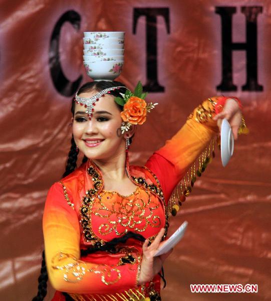 An actress of China's Xinjiang Returned Overseas Chinese Federation Performing Art Troupe performs in Almaty, Kazakhstan, Oct. 18, 2010. 