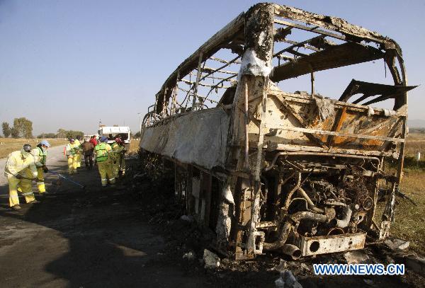 Workers clean the area near the remains of a bus and another vehicle in San Luis Potosi, outside Queretaro, Mexico, on Oct. 18, 2010. 